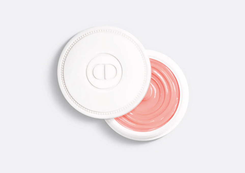 Pote redondo branco aberto com tampa ao lado, revelando um b&aacute;lsamo labial rosa p&ecirc;ssego com textura em espiral. A tampa tem o logo CD em relevo e borda pontilhada