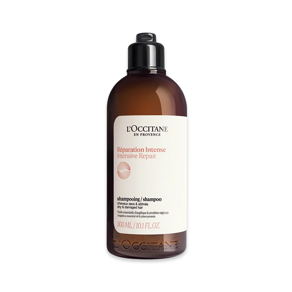 Frasco marrom escuro de shampoo LOccitane R&eacute;paration Intense Intensive Repair para cabelos secos e danificados, com tampa preta e r&oacute;tulo branco exibindo o logo e informa&ccedil;&otilde;es do produto em preto e vermelho, incluindo 300 ml