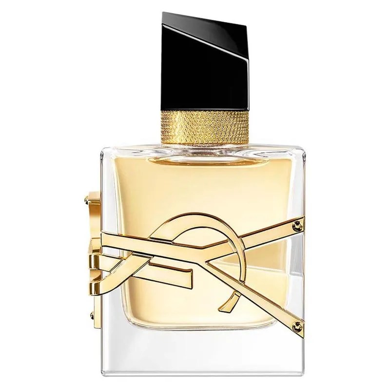Frasco de perfume retangular de vidro transparente com l&iacute;quido dourado, tampa preta inclinada e anel dourado texturizado, com o logotipo YSL dourado em relevo na frente