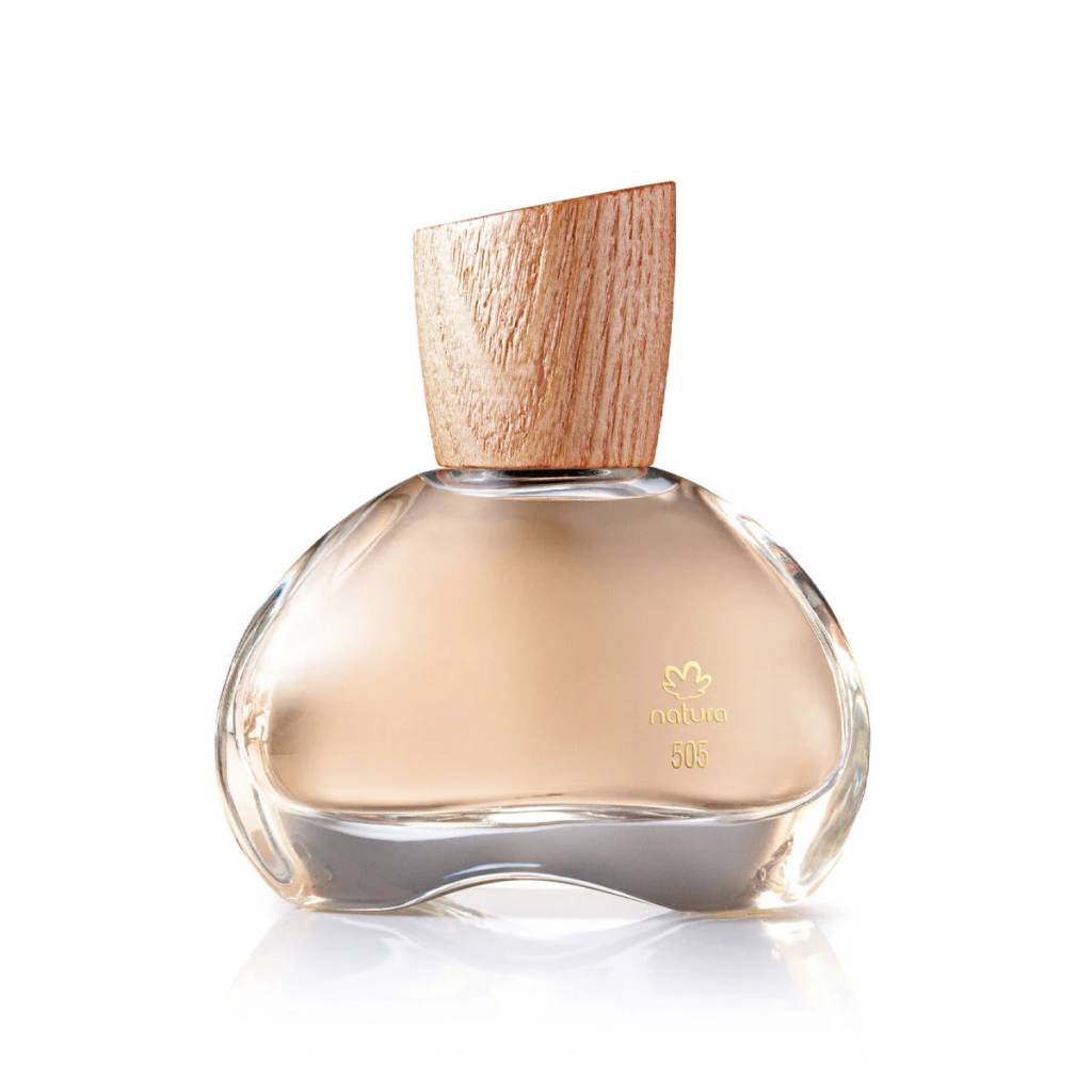 Frasco de perfume Natura 505 com l&iacute;quido bege claro, formato org&acirc;nico e tampa de madeira clara com corte diagonal, sobre fundo branco