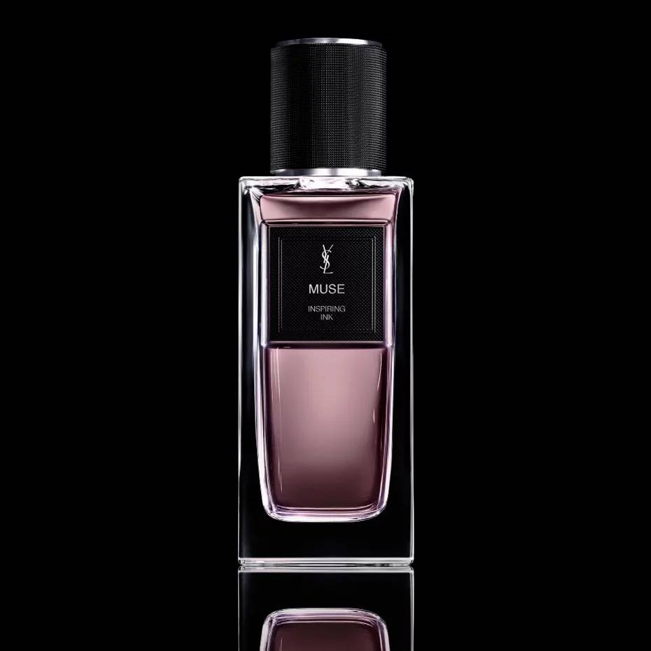 Frasco retangular de perfume Yves Saint Laurent Muse Inspiring Ink, com l&iacute;quido rosa-p&uacute;rpura e tampa preta texturizada, sobre fundo escuro com reflexo
