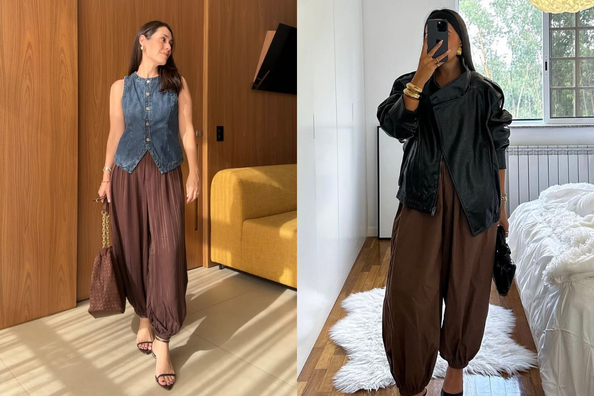 Duas mulheres posam com calças marrons estilo saruel. À esquerda, uma mulher sorri, vestindo colete jeans e sandálias pretas, segurando uma bolsa marrom com alça de corrente. À direita, outra mulher tira uma selfie no espelho, usando jaqueta preta de couro, sapatos pretos e pulseiras douradas, segurando uma bolsa preta.