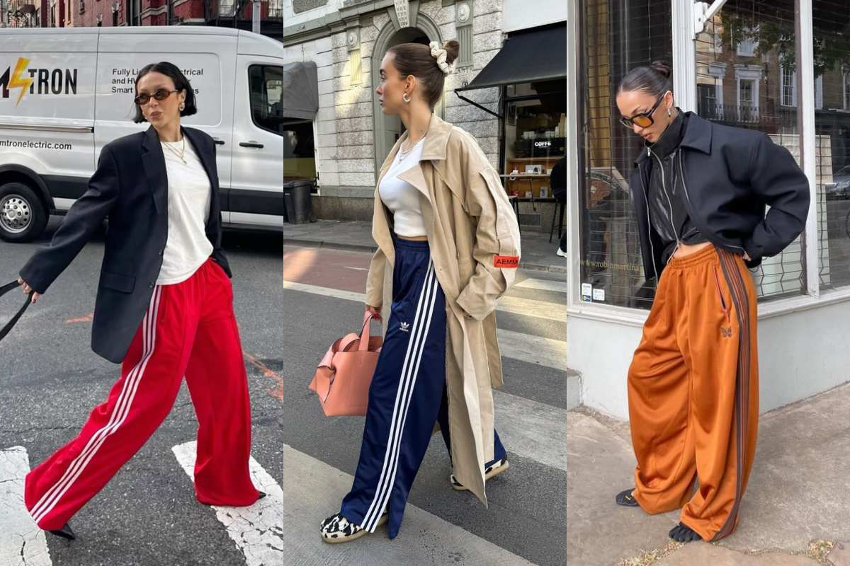 Três mulheres em poses diferentes, usando calças largas de moletom com listras laterais. A primeira veste calça vermelha, blazer preto e camiseta branca. A segunda usa calça azul-marinho, trench coat bege e blusa branca. A terceira veste calça laranja, jaqueta preta e blusa preta, com óculos de sol. Elas estão em ambientes urbanos, com prédios e ruas ao fundo