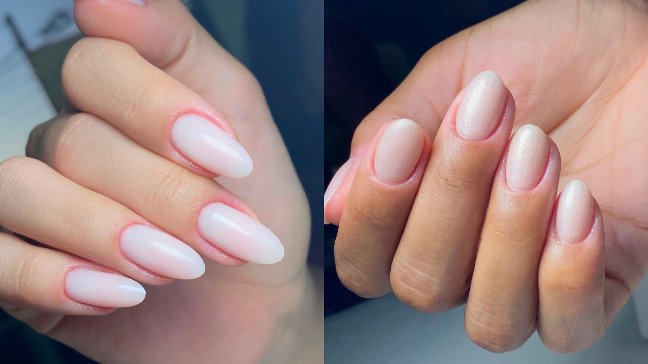 Duas mãos com unhas esmaltadas em tons claros. À esquerda, uma mão de pele clara com unhas ovais longas e esmalte branco leitoso. À direita, uma mão de pele morena com unhas ovais curtas e esmalte nude perolado